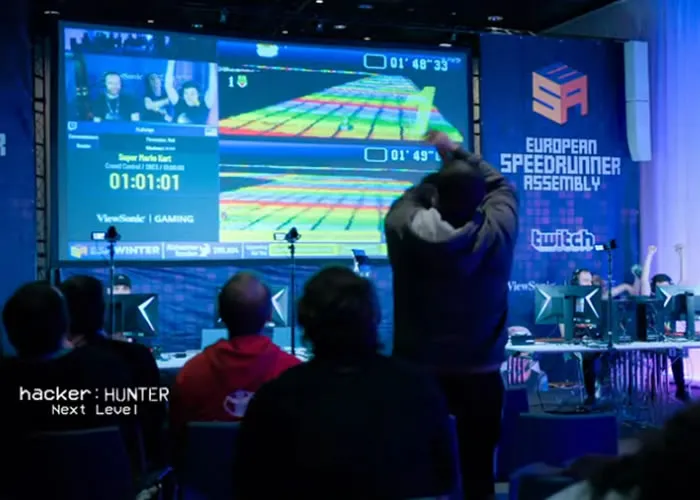 Um encontro de speedrunning é o local ideal para descobrir o que acontece quando os jogos de vídeo são levados ao extremo e é onde os melhores jogadores do mundo, por vezes com dezenas de milhares de horas de prática, colocam as suas técnicas à prova.

Speedrunning é completar um jogo o mais rápido possível, utilizando todos os meios necessários. Isto pode incluir de tudo, desde a exploração de falhas no software, até à adulteração dos comandos, ou apenas a utilização de técnicas à moda antiga.

Gidano, fundador da comunidade italiana de speedrunning, diz: "Penso que as pessoas entram neste modo porque gostam tanto de um jogo que querem jogá-lo repetidamente e aprender todos os seus aspectos".

Aprender todos os aspectos de um jogo de vídeo inclui muitas vezes descobrir falhas, que são pequenas falhas na programação que os criadores do jogo não pretendiam ter, mas que são muitas vezes uma forma elegante de os speedrunners contornarem os jogos para os terminarem ainda mais rapidamente.

As falhas podem ser usadas para enganar o jogo, levando-o a um lugar onde não é suposto estar, por exemplo saltando uma parede, ou para o ajudar a matar um inimigo, desativando as suas armas numa luta.

Algumas comunidades que praticam o speedrunning vão um passo mais longe e adulteram os comandos para ganharem velocidade - uma prática que é considerada perfeitamente legítima dentro do grupo.

As maratonas de caridade também desempenham um papel importante, com jogadores de todo o mundo a angariarem mais de 3 milhões de dólares para ações de caridade em 2021.

Fredrik "Edenal" Lidholt é o fundador da Assembleia Europeia de Speedrun, que reúne os jogadores em Malmo, na Suécia, duas vezes por ano.

Os speedrunners jogam e transmitem jogos de vídeo, durante sete dias seguidos, dia e noite, numa maratona para angariar dinheiro para várias causas. O evento ESA Winter 2022 angariou mais de 106 mil dólares para a Alzheimerfonden, uma fundação de bolsas de investigação da doença de Alzheimer.

Fredrik é apaixonado pelo potencial do jogo e explica: "Se se vai ao cinema, não se interage. É só um mero espetador. Através de doações e ao ter alguém ao lado para narrar e comentar, é uma forma de interagir com as pessoas que assistem. Caridade e jogos é uma combinação perfeita."

O verdadeiro crime entra online: todas as semanas em Hacker Hunter analisamos histórias da vida real de hackers dentro da indústria dos jogos e descobrimos se o hacking pode ser uma força para o bem., Baixar Kaspersky Anti-Virus, ESA Winter 2023 e Alzheimerfonden, em, Brasil